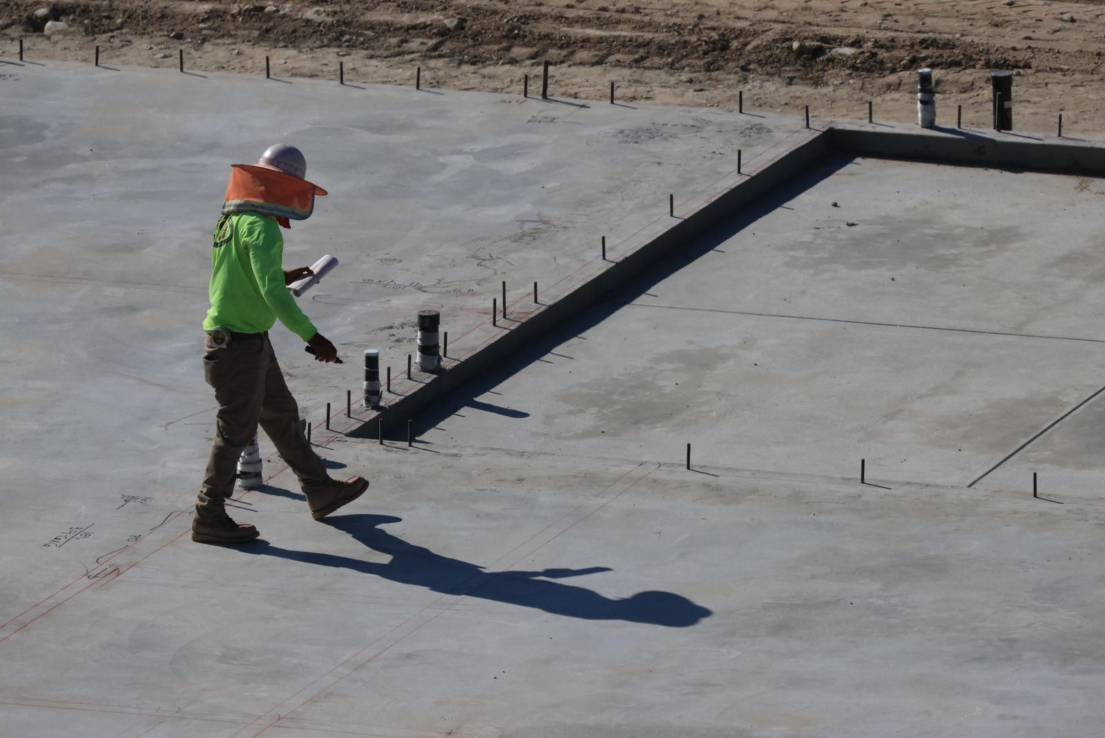 Construction professionals inspecting a concrete slab